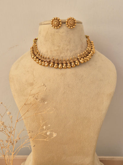 Tanya Necklace Set in antique gold finish displayed on a mannequin with matching stud earrings by Naitri
