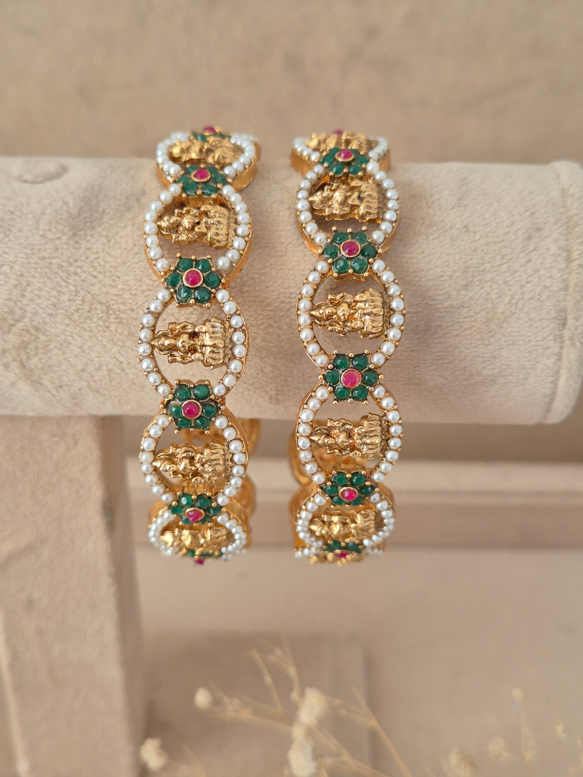 Set of two traditional stone and pearl studded gold-plated bangles by naitri.in