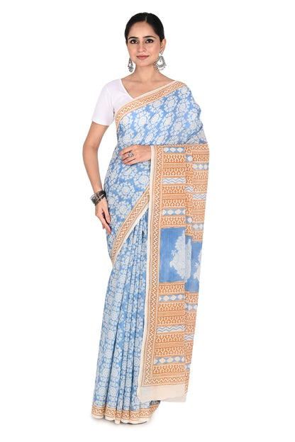 Woman modeling the Tapti Hand Block Printed Cotton Saree, a white and blue breathable cotton saree featuring intricate Bagh geometric patterns and a classic drape by naitri.in