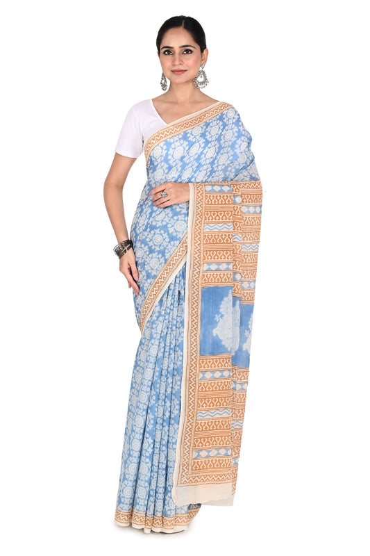 Woman modeling the Tapti Hand Block Printed Cotton Saree, a white and blue breathable cotton saree featuring intricate Bagh geometric patterns and a classic drape by naitri.in
