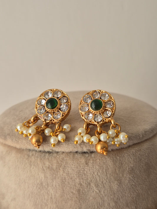 Gold earrings with green gemstones and pearls- golden beads hanging down from the flora designed earrings by naitri.in