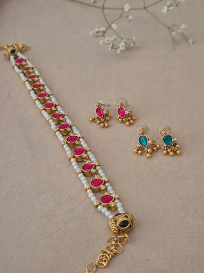 A multi-strand white pearl choker necklace with teardrop-shaped pink stones and matching stud earrings by naitri.in