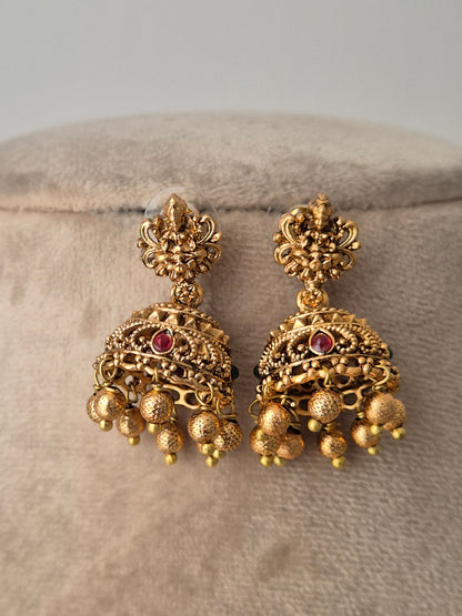 Pair of gold earrings with red gemstones goddess motif and golden beads attached with jhumki by naitri.in
