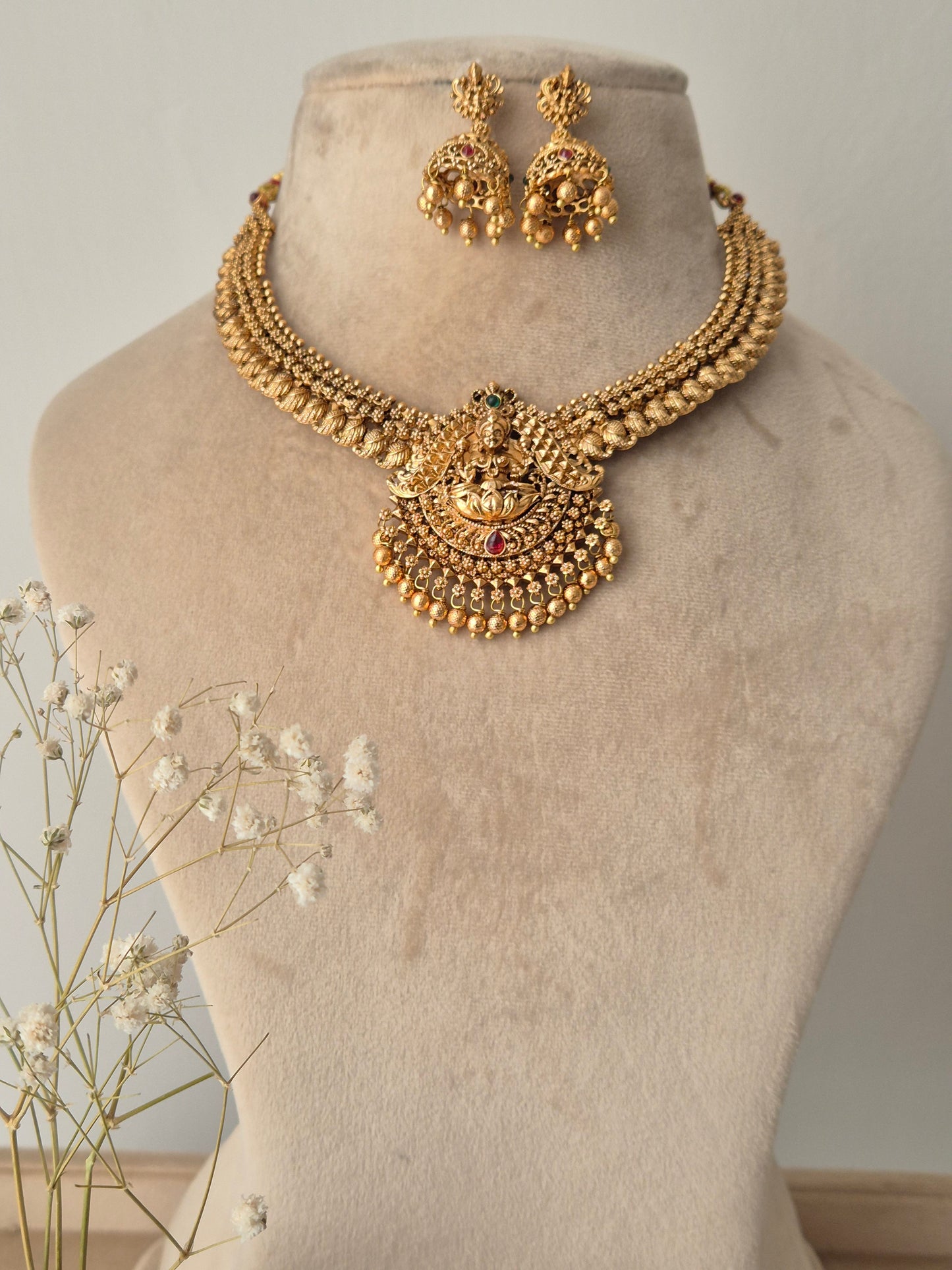 Gold necklace and earrings with red- green stones by naitri.in