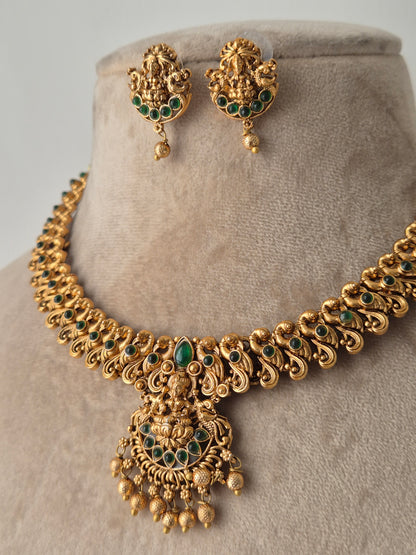 A showstopper piece with green stones and golden beads dropping down by naitri.in