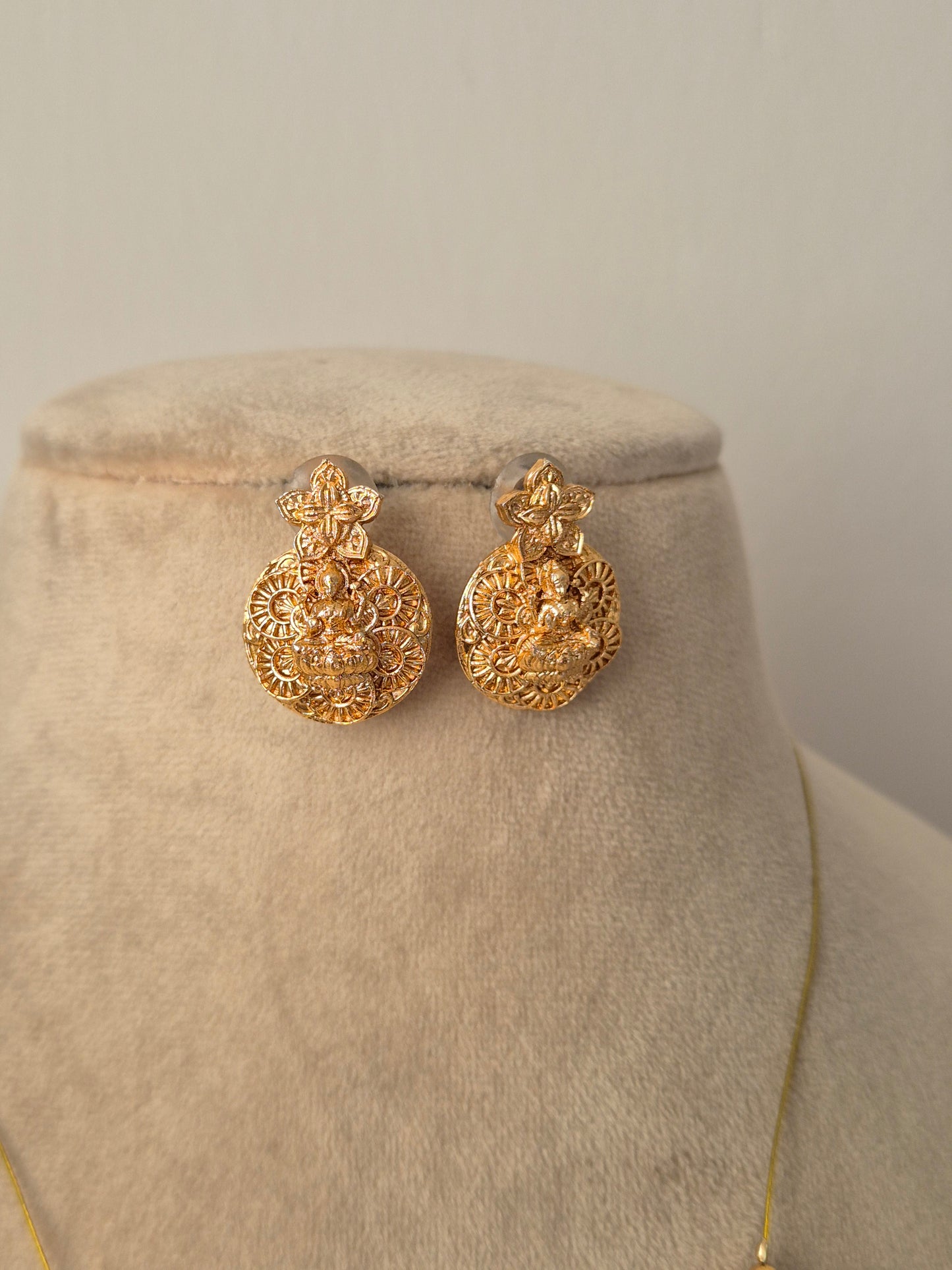 Gold earrings Antique gold-plated, featuring a central Goddess Lakshmi motif by naitri.in