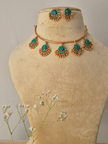 Handcrafted gold-polished brass choker featuring turquoise-green stone pendants with gold bead fringes and matching turquoise stud earrings by naitri.in