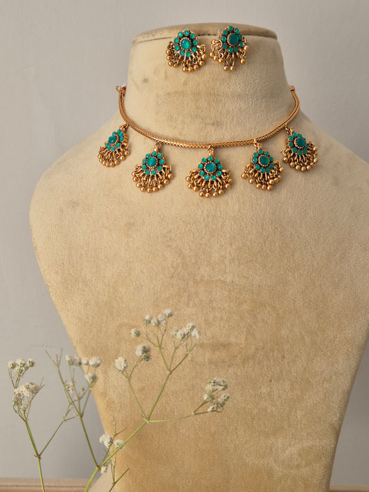 Handcrafted gold-polished brass choker featuring turquoise-green stone pendants with gold bead fringes and matching turquoise stud earrings by naitri.in