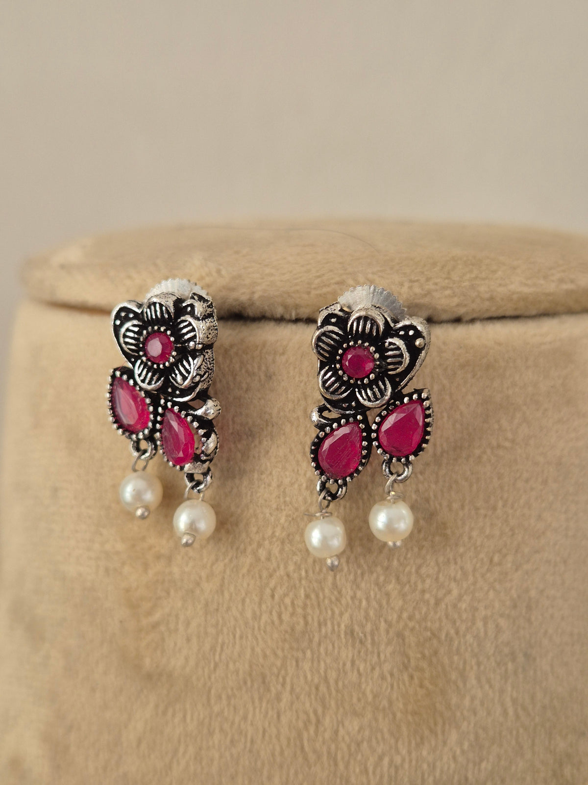 Pair of oxidized silver floral motif earrings redish piink stone oxidized silver earrings  with dangling mini pearls by naitri.in