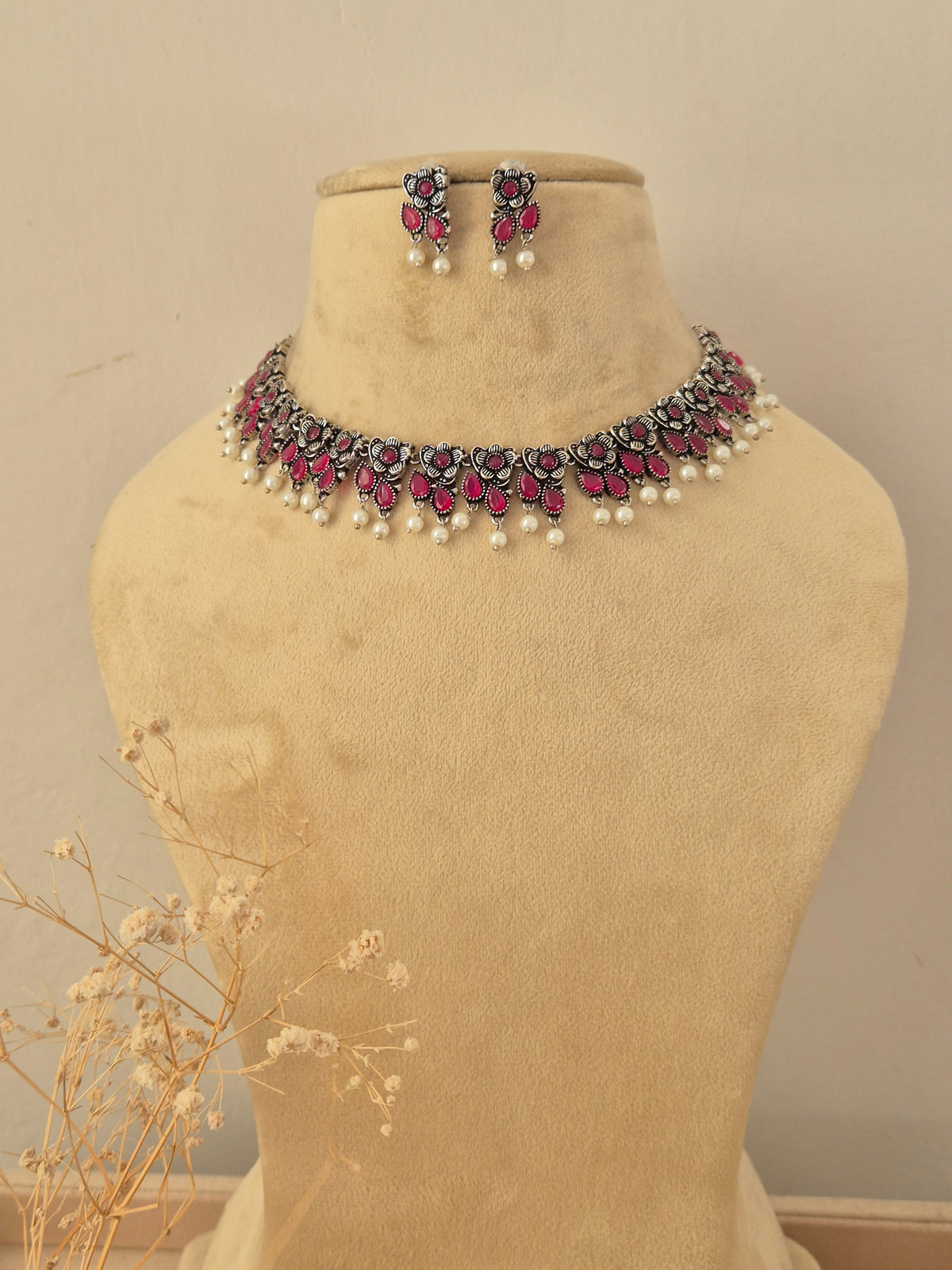 Uapasana  silver oxidized necklace set with redish pink stone embellishments and pearl drop accents by naitri.in