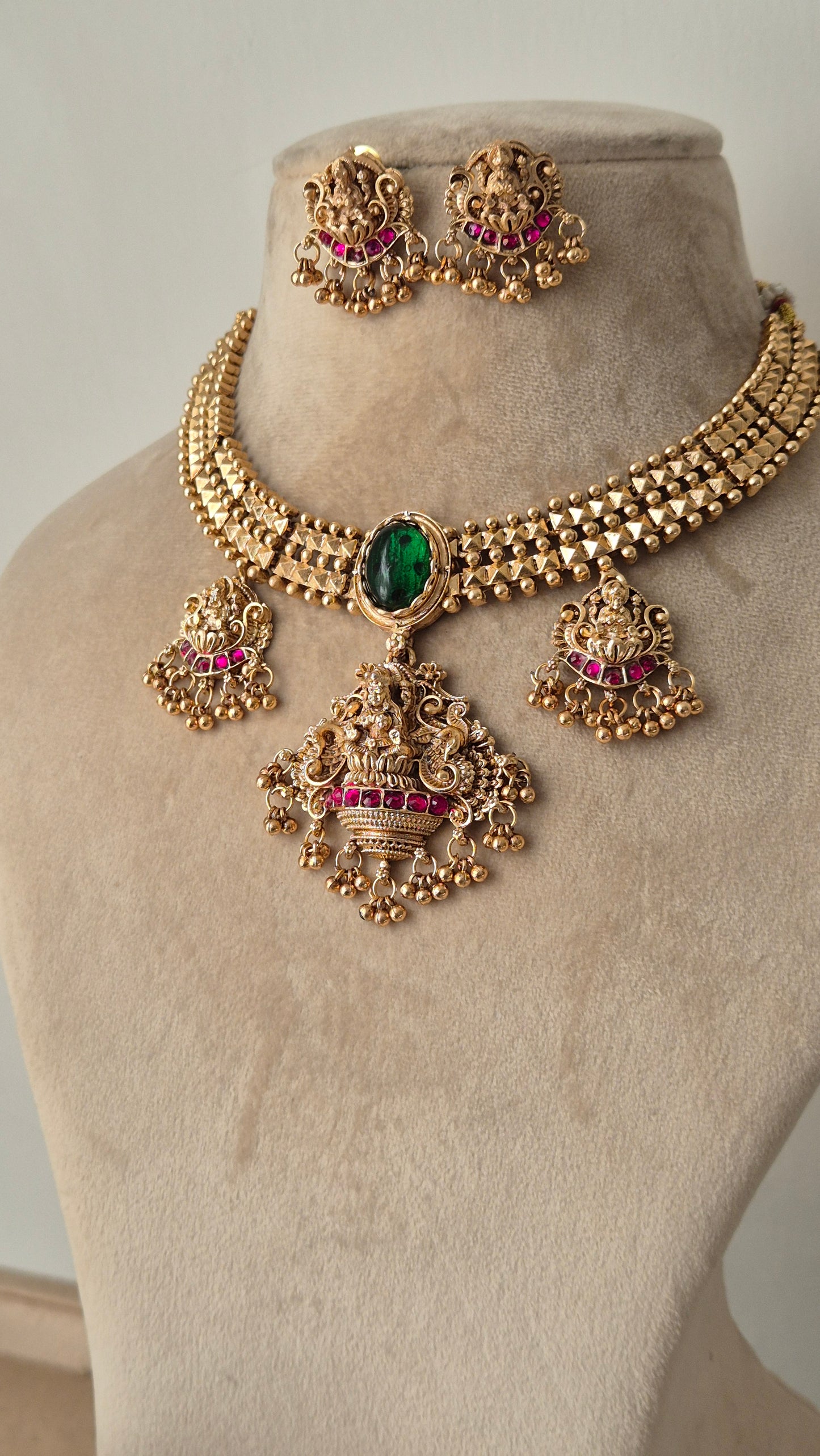 goddess motifs with small golden beads hanging big spherical green emerald in the middle of necklace and some eye catching pink stones by naitri.in