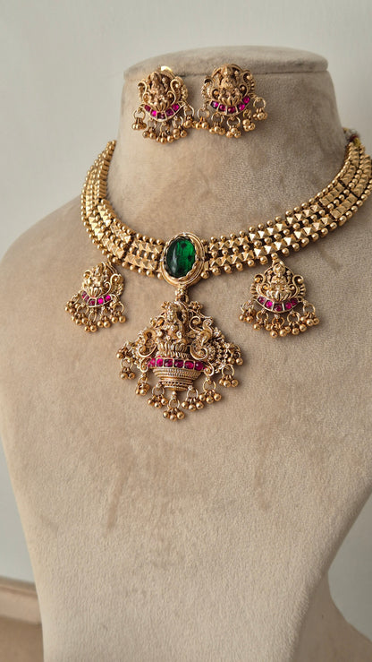 goddess motifs with small golden beads hanging big spherical green emerald in the middle of necklace and some eye catching pink stones by naitri.in