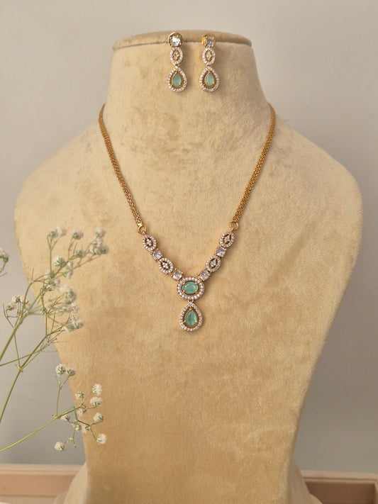 Gold-plated brass chain necklace with mint green teardrop stone pendants and matching drop earrings by naitri.in