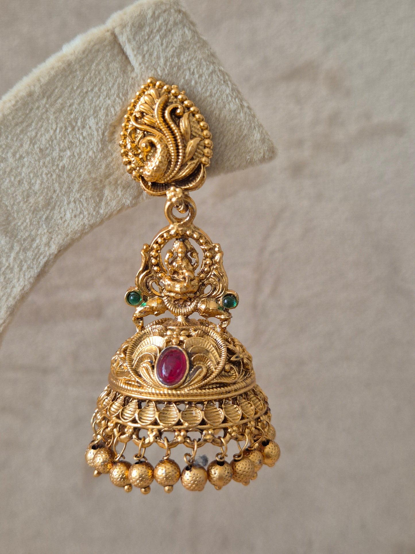 Handcrafted  earrings in brass alloy featuring a polished golden finish and vibrant red and green stone embellishments by naitri.in