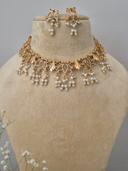 Gold-finished brass alloy choker necklace set with pearl drops and matching earrings, by naitri.in