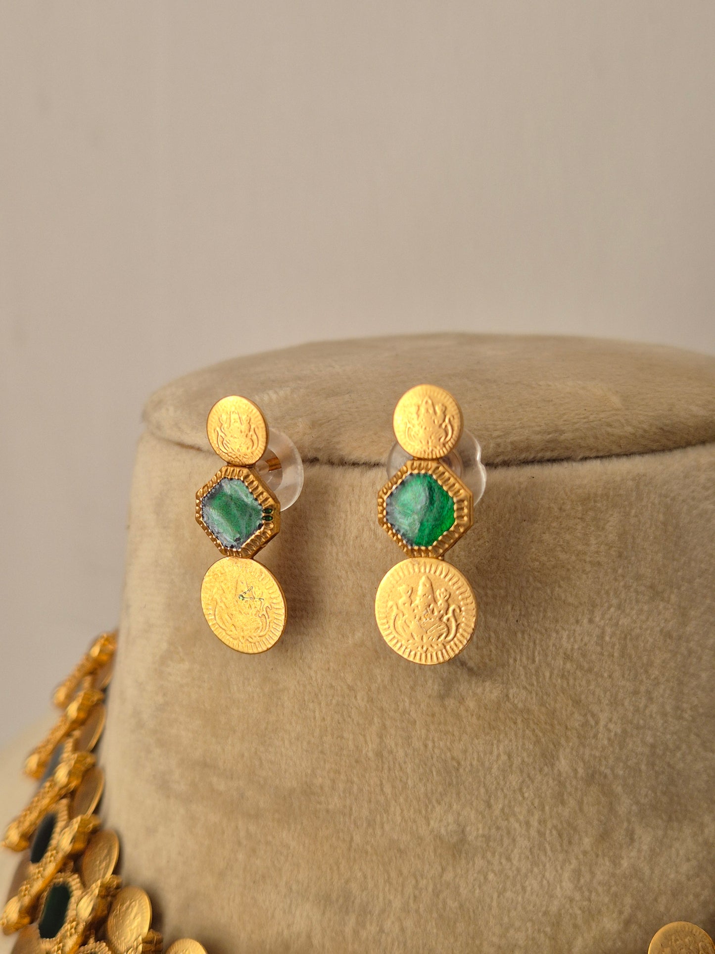 Gold-plated brass earrings with green stone embellishments, a dangling coin fringe by naitri.in