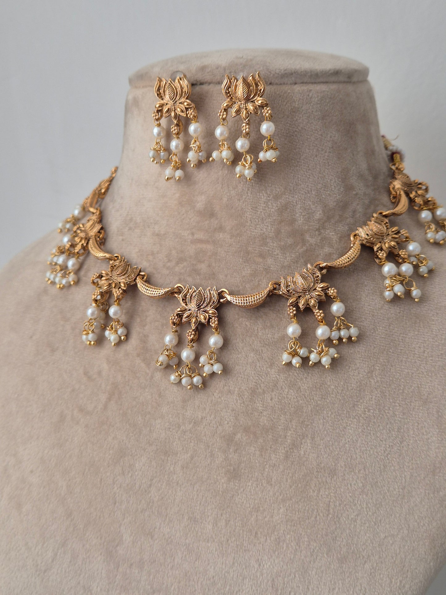  gold accents beautifully created lotus design connecting other pearls hanging from lotus leaves by naitri.in