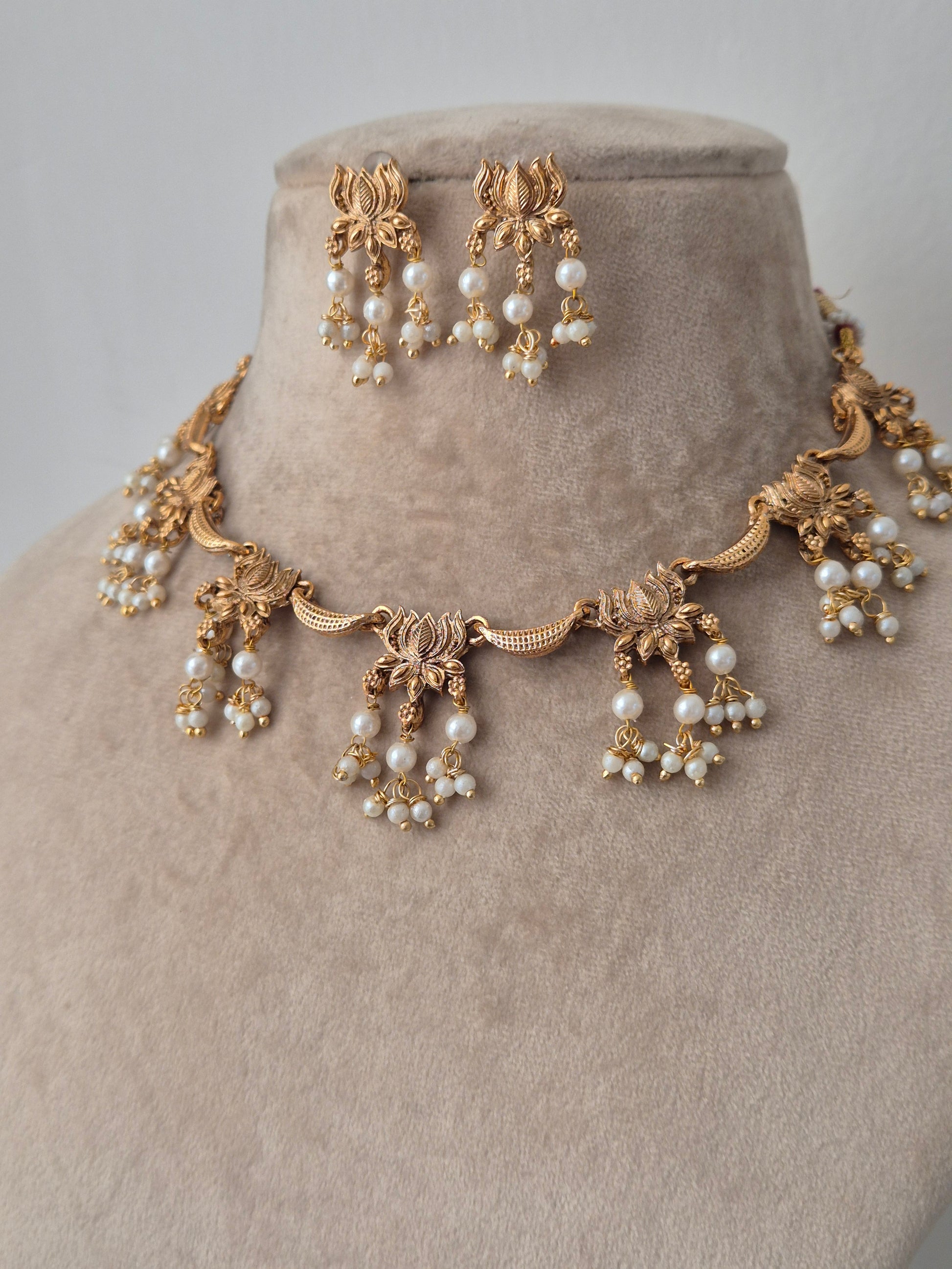  gold accents beautifully created lotus design connecting other pearls hanging from lotus leaves by naitri.in