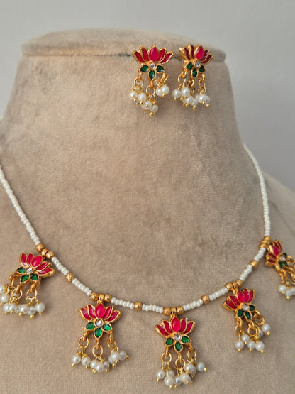 Jewelry set with pink-green and gold elements with Pair of gold earrings with pink petals and green leaves, a small stone in the middle and white pearls by naitri.in