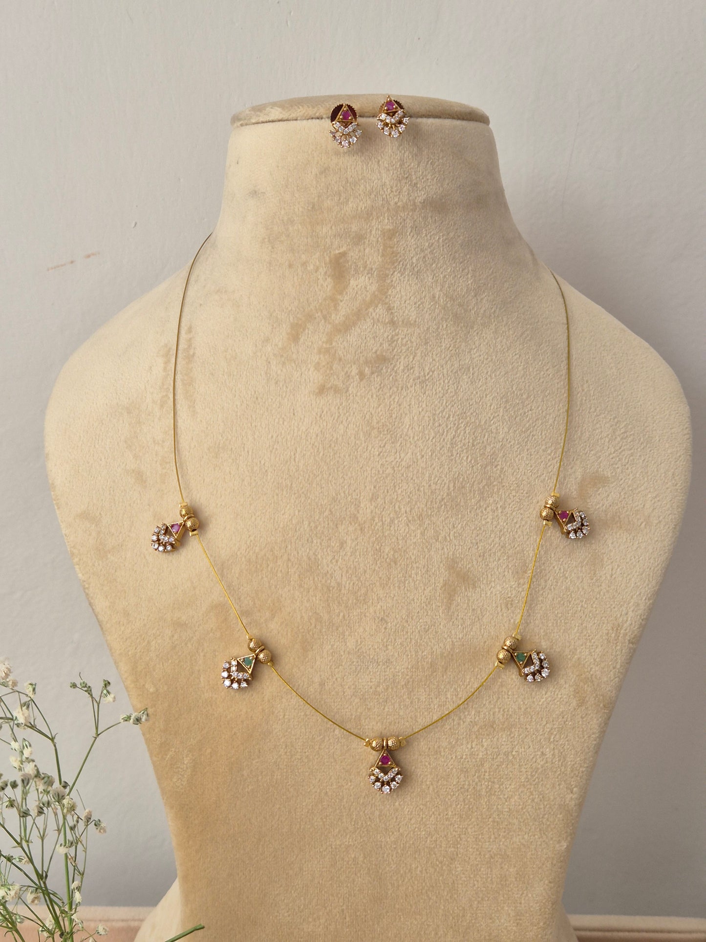 Minimalist gold invisible chain necklace with hanging textured crescent-shaped pendants and matching earrings by naitri.in