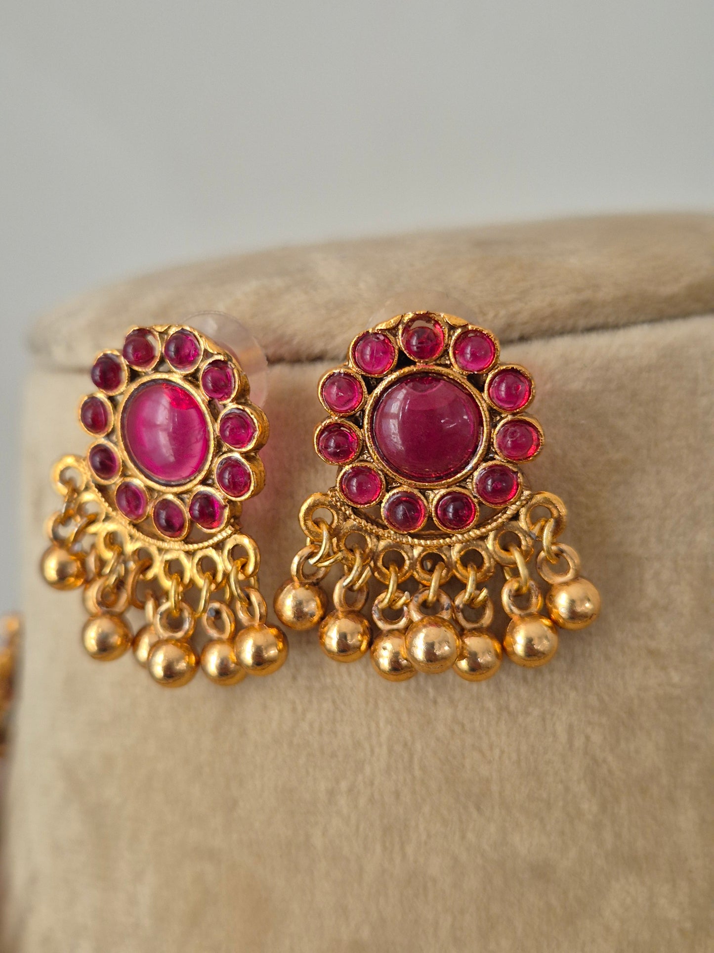 Elegant handcrafted brass alloy necklace set with a polished golden finish and vibrant red stone embellishments, by naitri.in