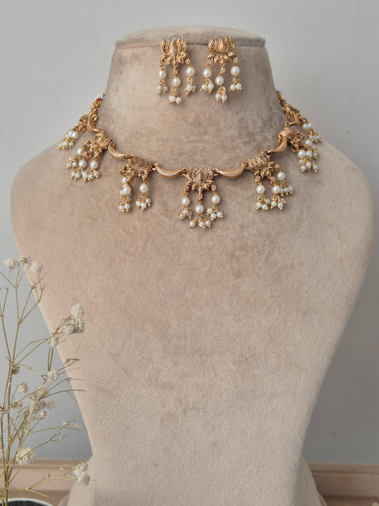 Decorative neckpiece with pearls and gold accents beautifully created lotus design connecting other pearls hanging from lotus leaves by naitri.in