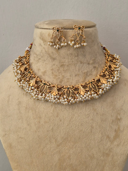 Gold-toned traditional jewelry set featuring a wide floral choker necklace and matching drop earrings with small pearl-like beads by naitri.in