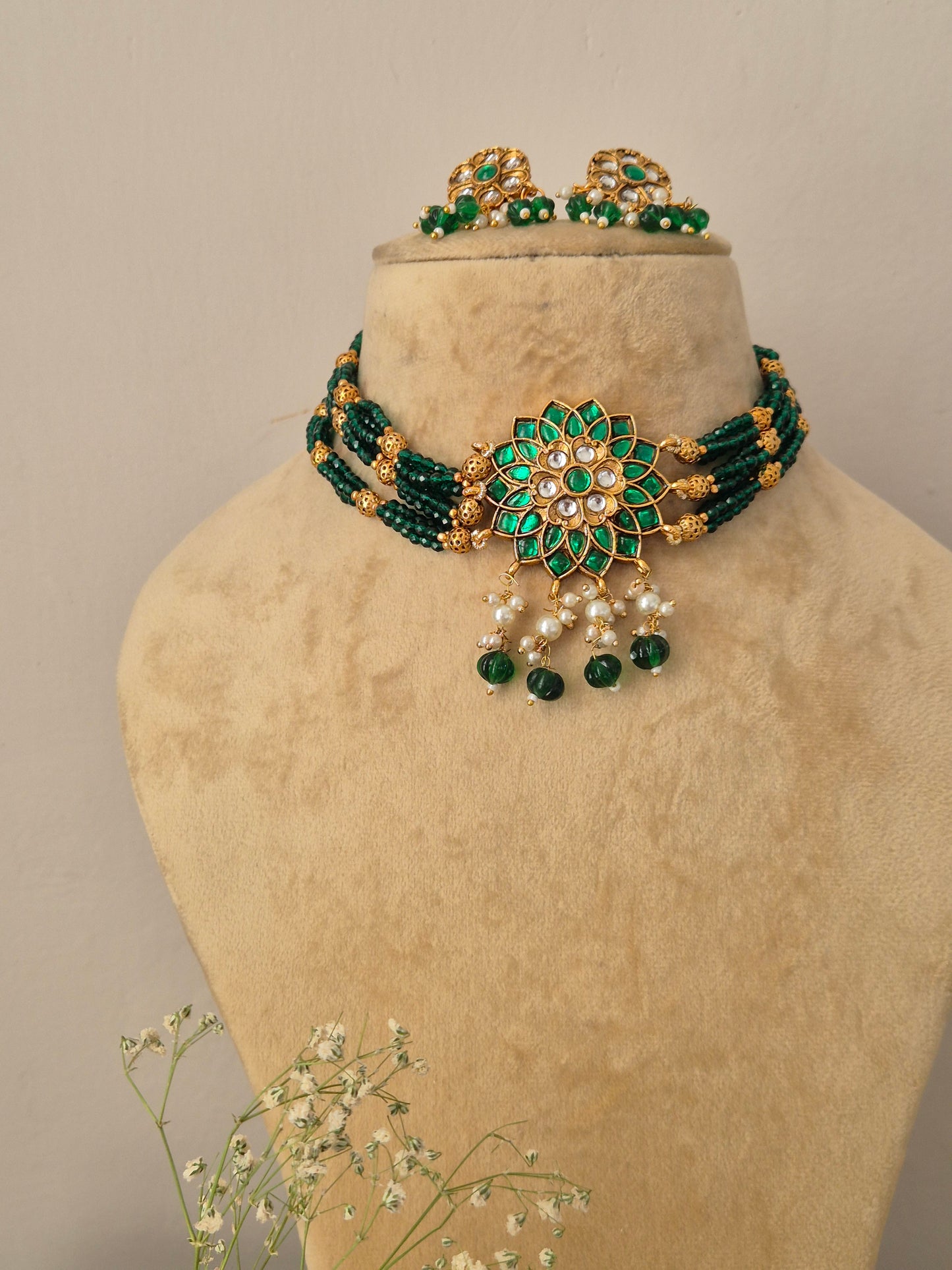 Handcrafted antique gold statement choker set showcasing rich green beadwork and floral stone embellishments, by naitri.in