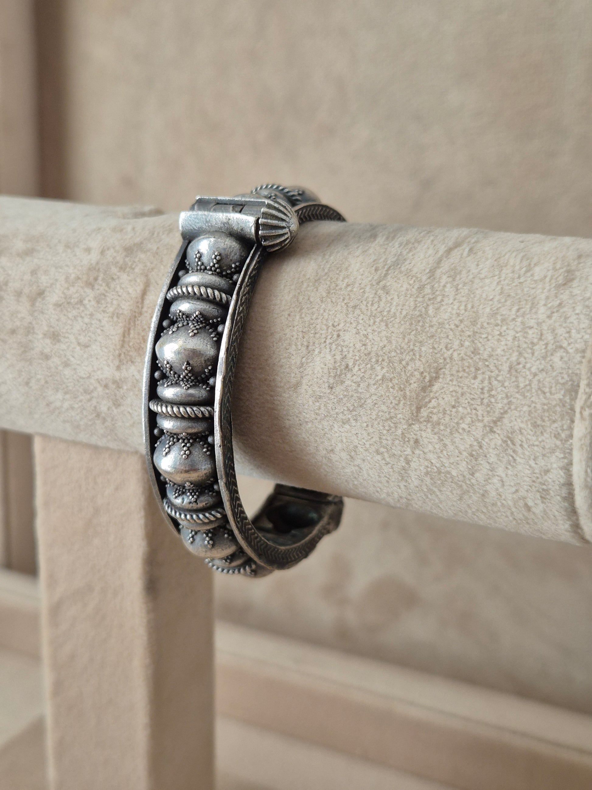 Detailed antique silver oxidized bangle with an embossed textured pattern by naitri.in