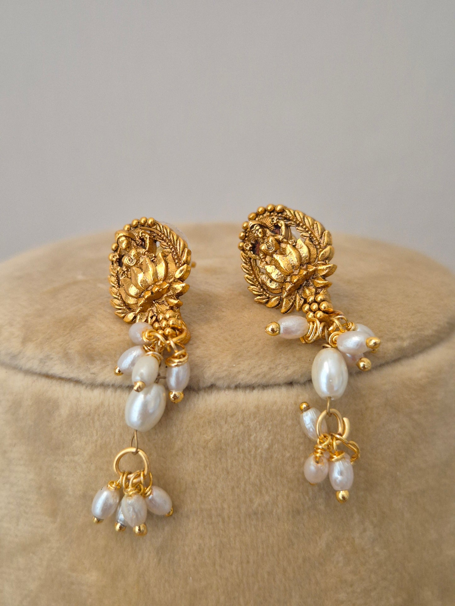 the NAITRI golden earrings, featuring a brass alloy earrings with dangling pearls by naitri.in