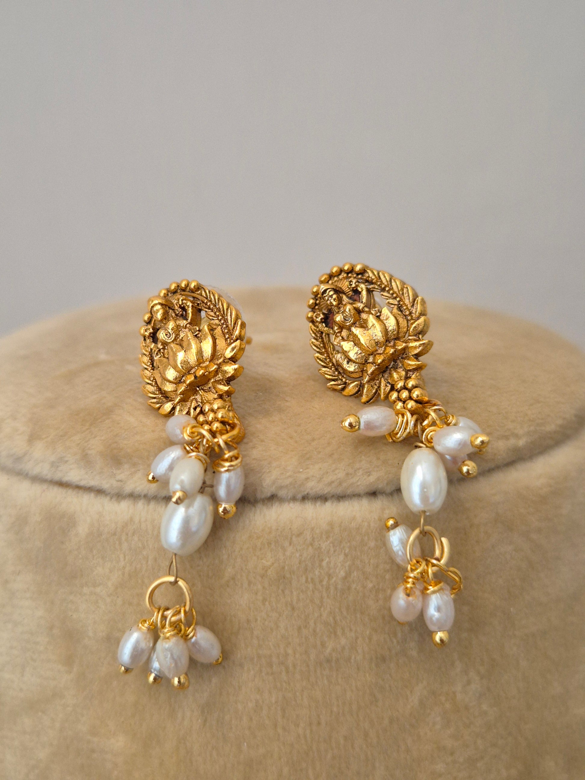 the NAITRI golden earrings, featuring a brass alloy earrings with dangling pearls by naitri.in