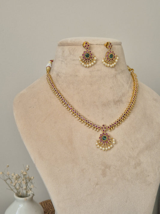 Sophisticated metal alloy necklace set photographed on a plain background to show classic design