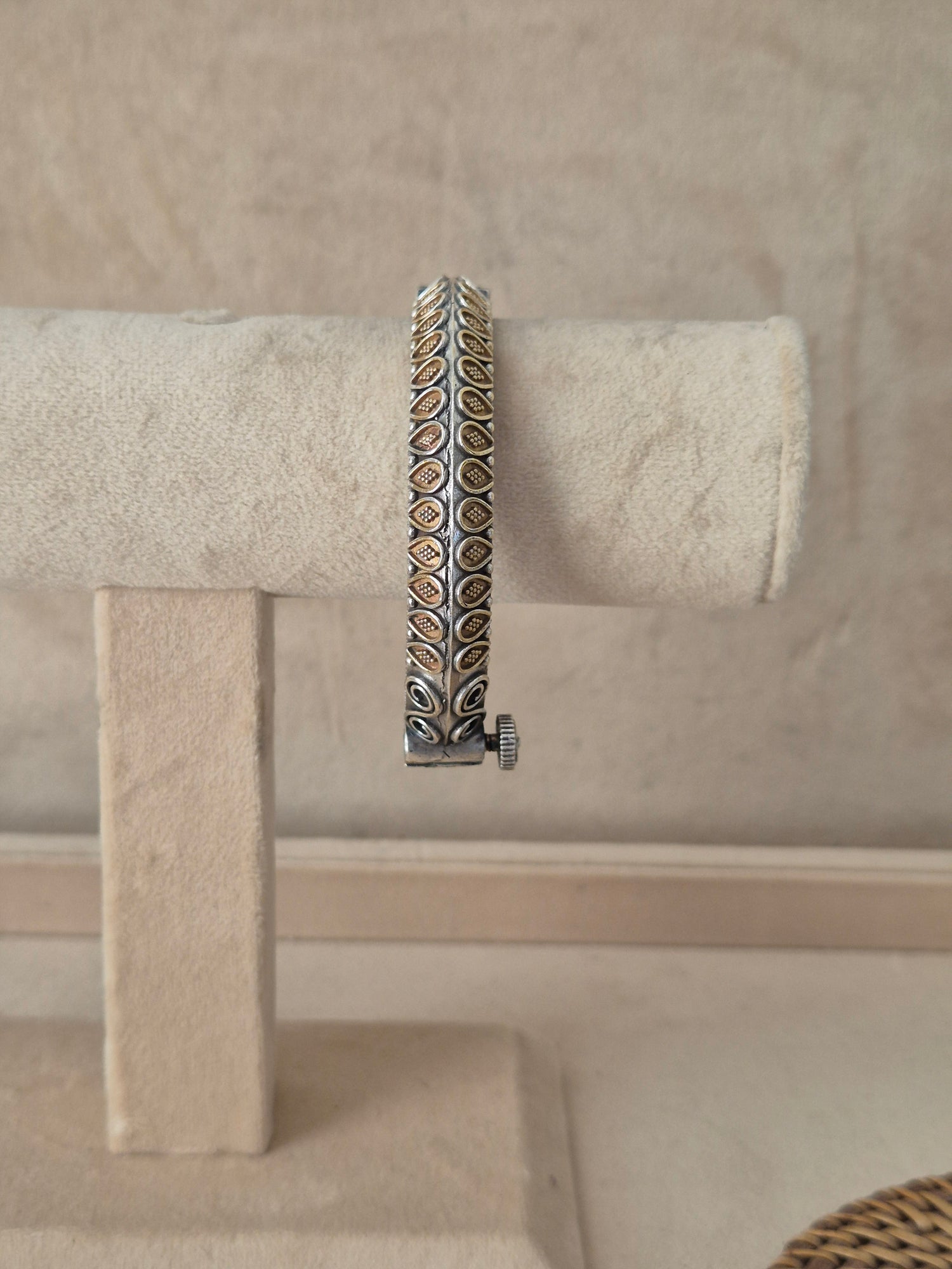 Dual-tone Windiya openable bangle bracelet featuring an intricate alternating pattern of textured oxidized silver panels and polished gold-toned accents, by naitri.in