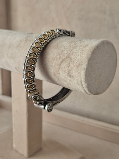Statement gold and silver-plated festive Kada bangle featuring detailed mesh-like open-work textures and fine metallic borders by naitri.in