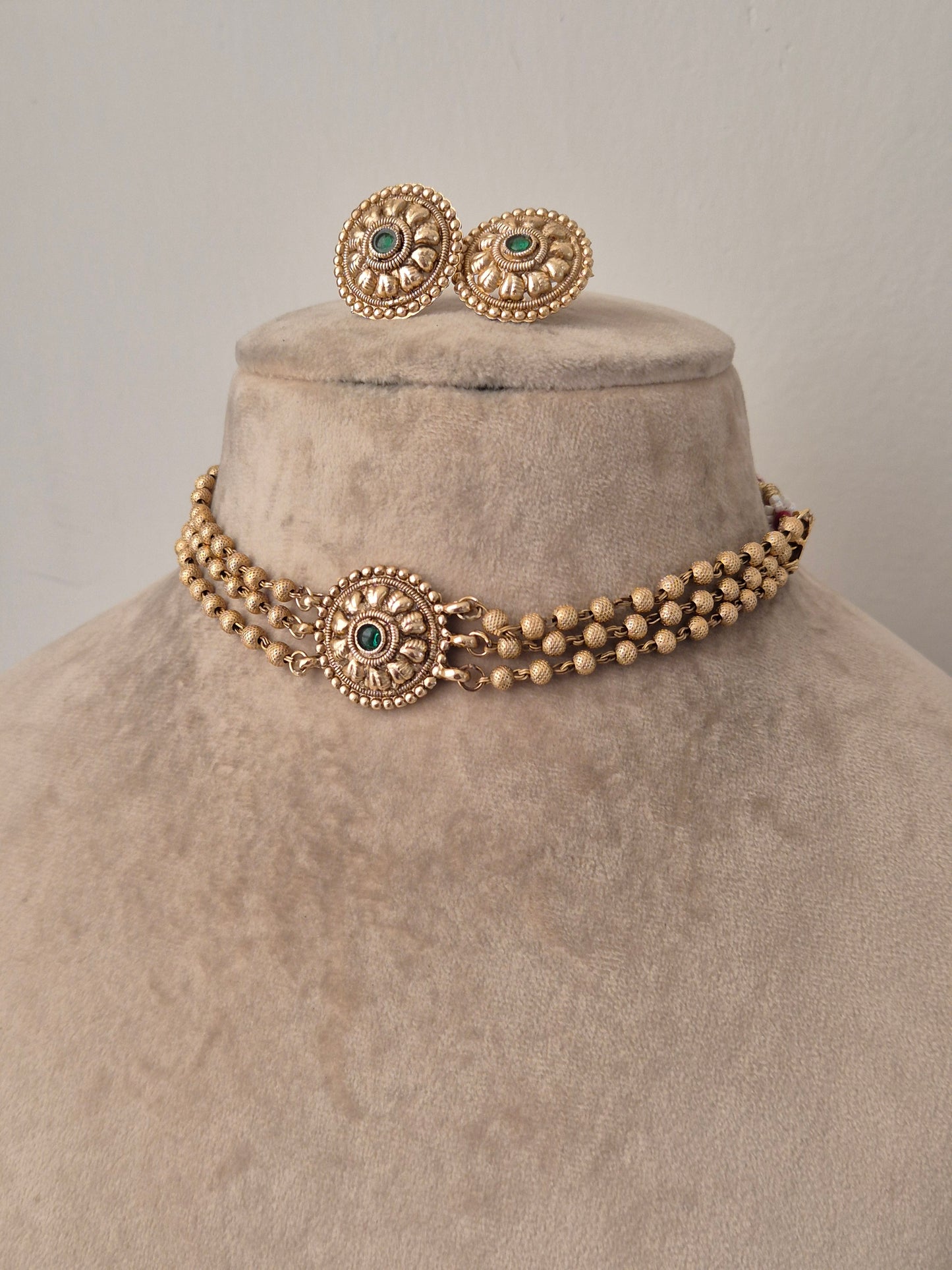 Golden necklace and earring studs with green gemstone in the middle, 3 layered necklace by naitri.in