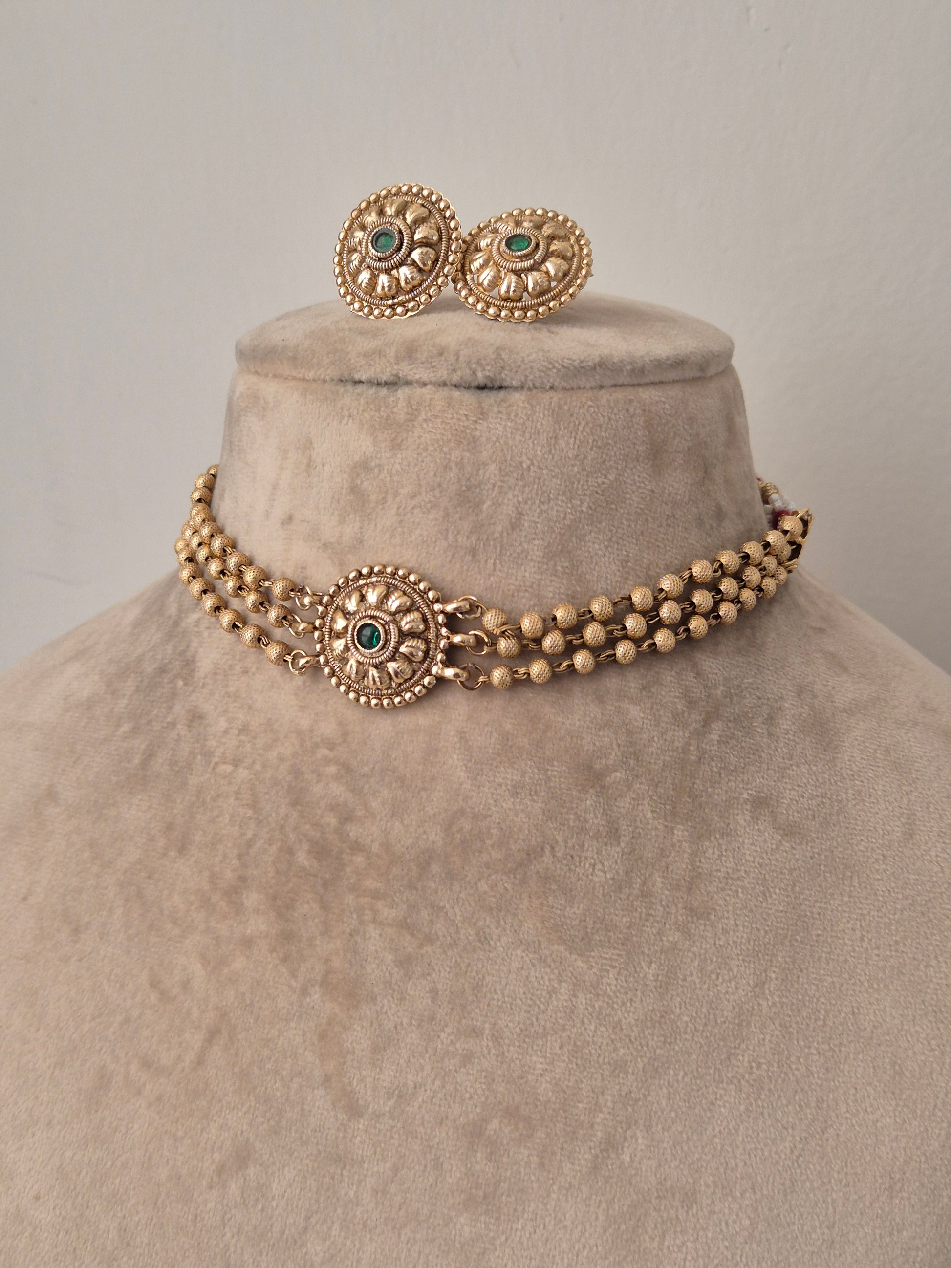 Golden necklace and earring studs with green gemstone in the middle, 3 layered necklace by naitri.in