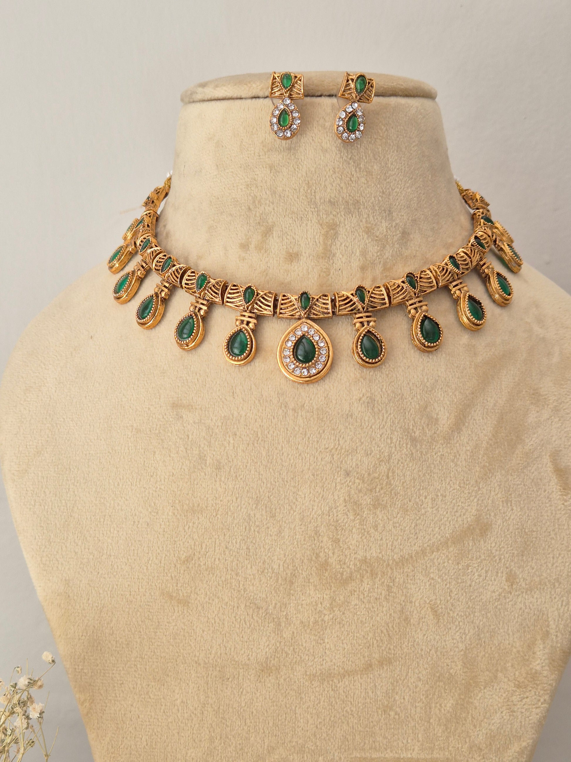 Necklace Set by Naitri featuring an ethnic gold-plated choker and matching traditional drop earrings with green teardrop stones for festive wear by naitri.in