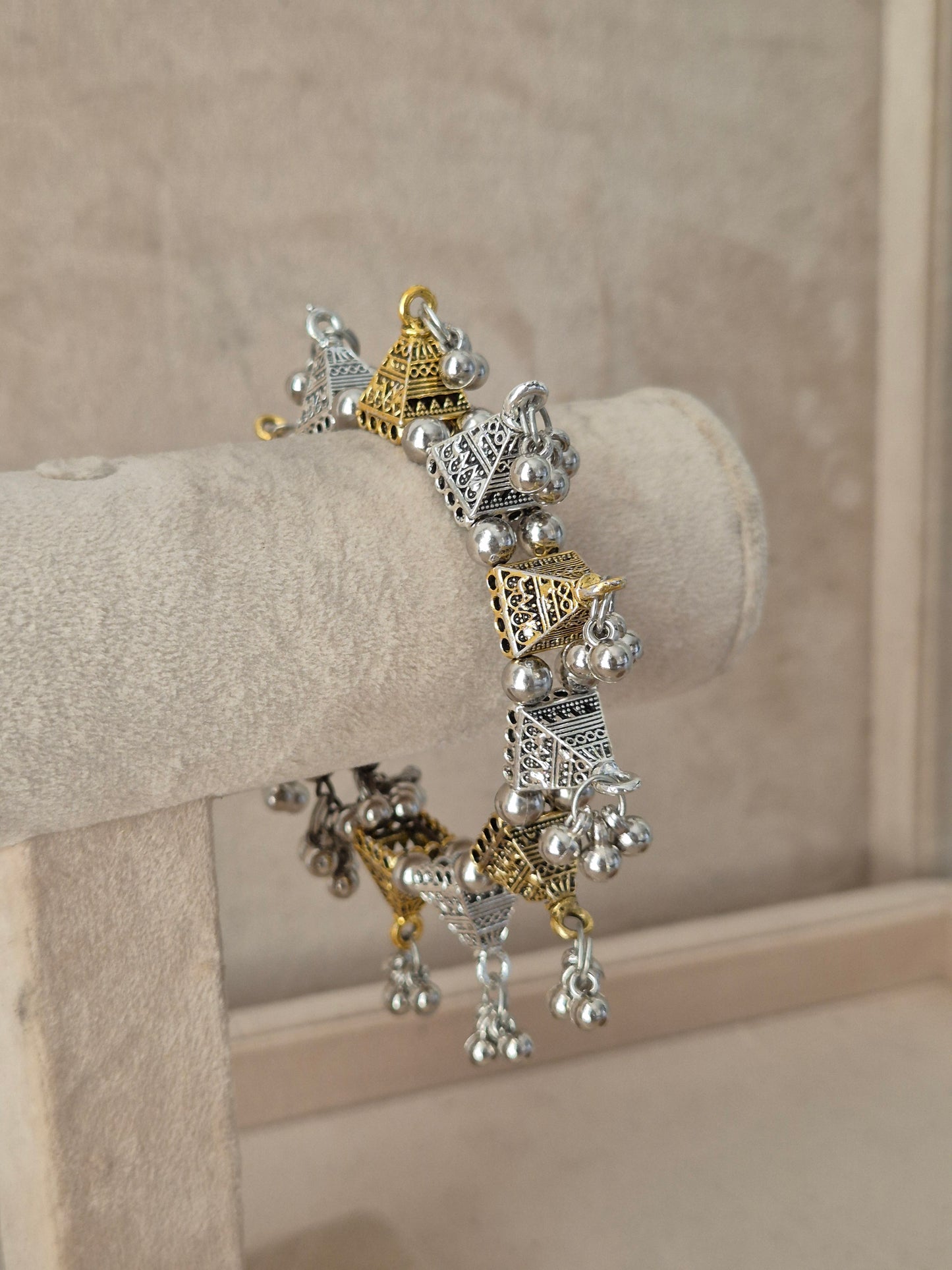 Close-up of Naitri Yachana premium mixed-metal ethnic bracelet showcasing traditional Indian tribal craftsmanship with a vintage, antique finish and hanging bell clusters by naitri.in