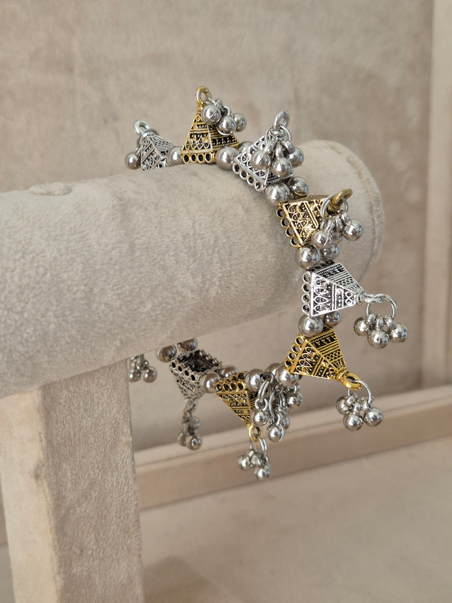Dual-toned gold and silver Yachana bangle with textured geometric blocks and hanging silver ghungroo charms. Elegant dual-tone ethnic cuff bracelet with traditional festive details, by naitri.in