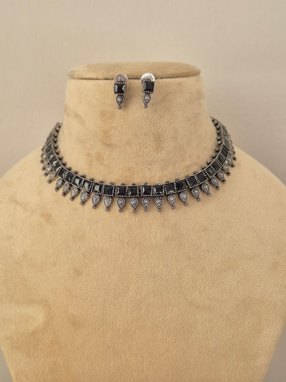 Oxidized silver brass alloy choker necklace set featuring classic Indian motifs and pearl accents by Naitri.in