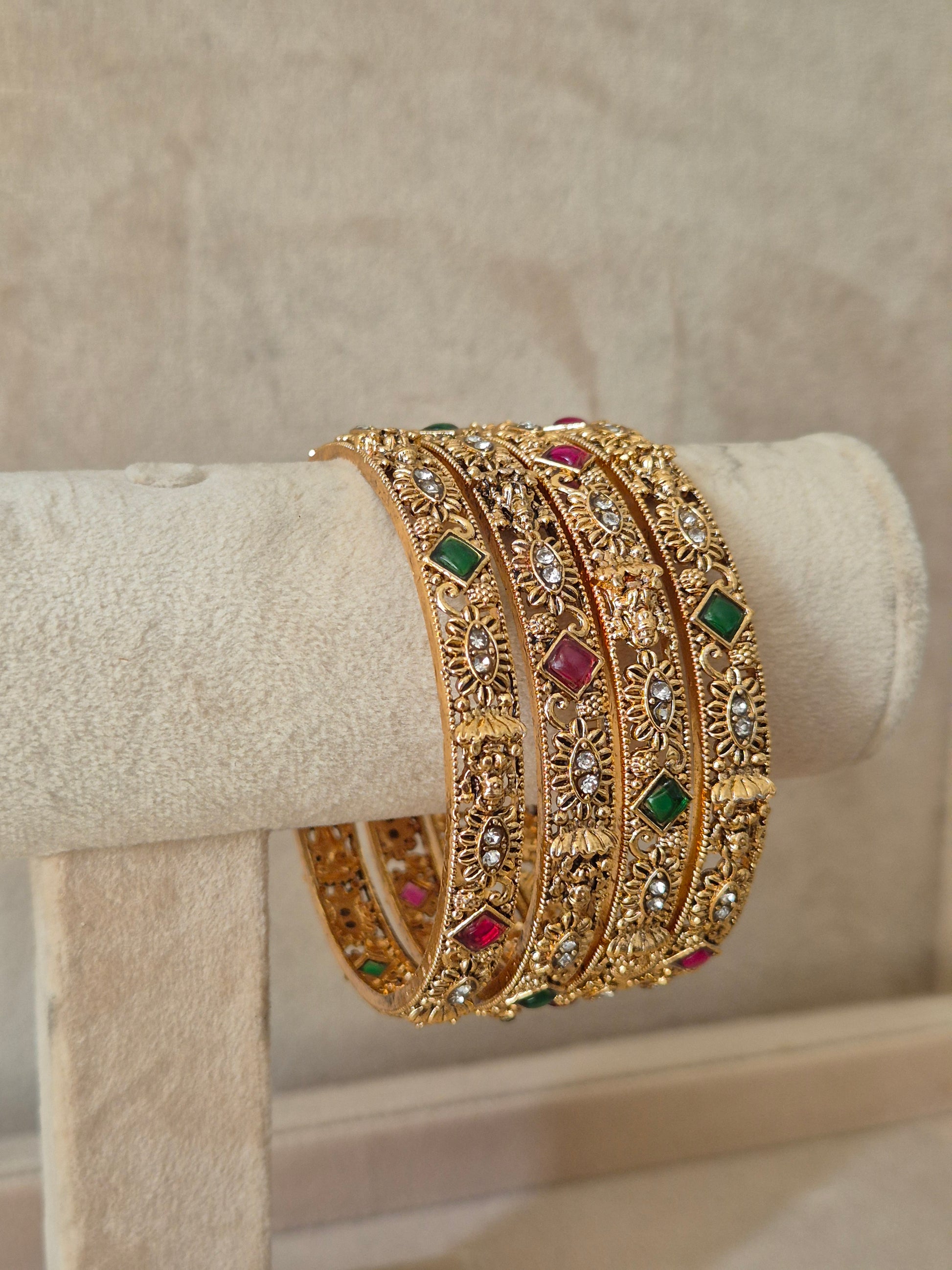 Gold bracelet with gemstones Elegant golden statement bangles with ethnic gemstone details by naitri.in