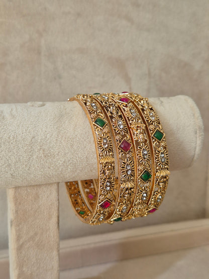 Gold bracelet with gemstones Elegant golden statement bangles with ethnic gemstone details by naitri.in