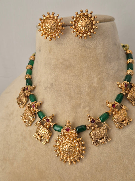  Traditional gold-plated choker with green beads and red stone accents and matching floral studs by naitri.in