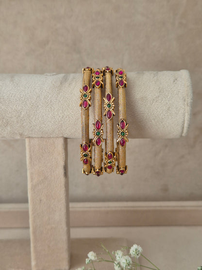 Antique gold bangle set of four adorned with red and green gemstones by naitri.in