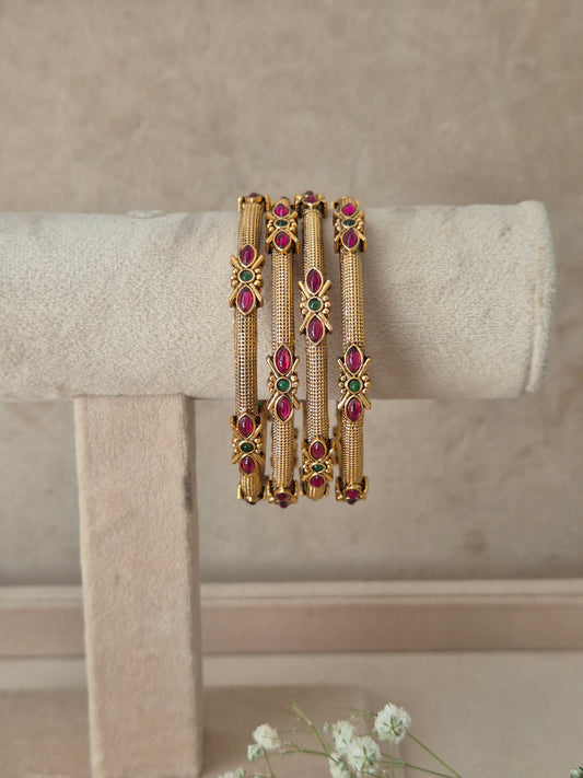 Antique gold bangle set of four adorned with red and green gemstones by naitri.in