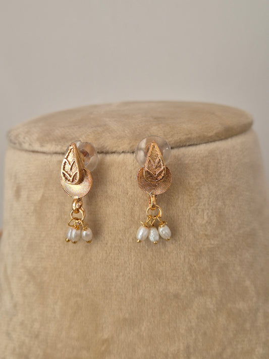 Elegant brass alloy necklace set in gold with small white pearls arranged in a tiered tassel design, perfect for festive wear by naitri.in