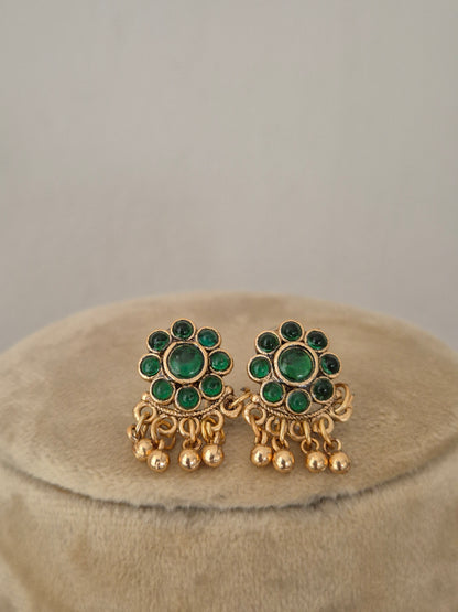 Antique gold-toned earrings intricate metallic round floral vibrant green stone clusters, and delicate hanging gold bead drops by naitri.in