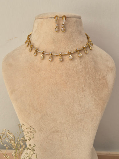 Gold-toned jewelry set including a delicate necklace piece with teardrop charms and matching drop earrings, by naitri.in