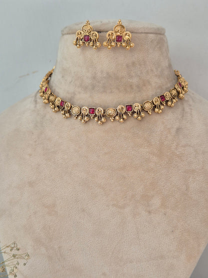 Gold-toned traditional Indian jewelry set featuring a bracelet and matching earrings with small red square gemstones, by naitri.in