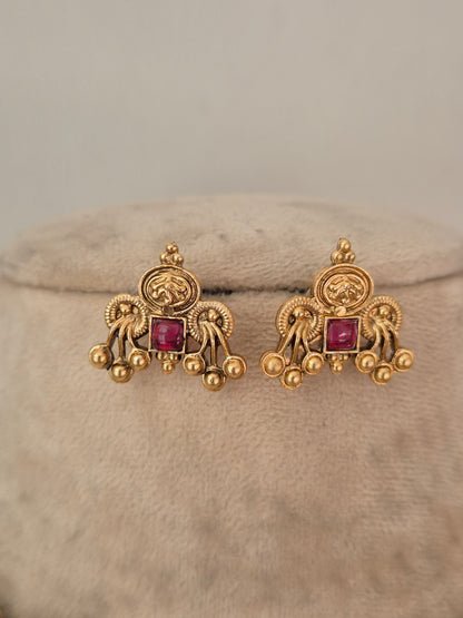 A pair of ornate gold earrings with square pink gemstones, by naitri.in